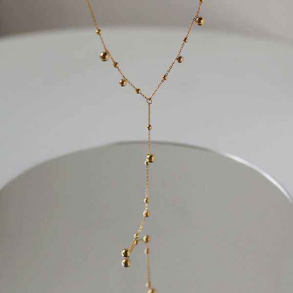 Irregular falling gold bead necklace